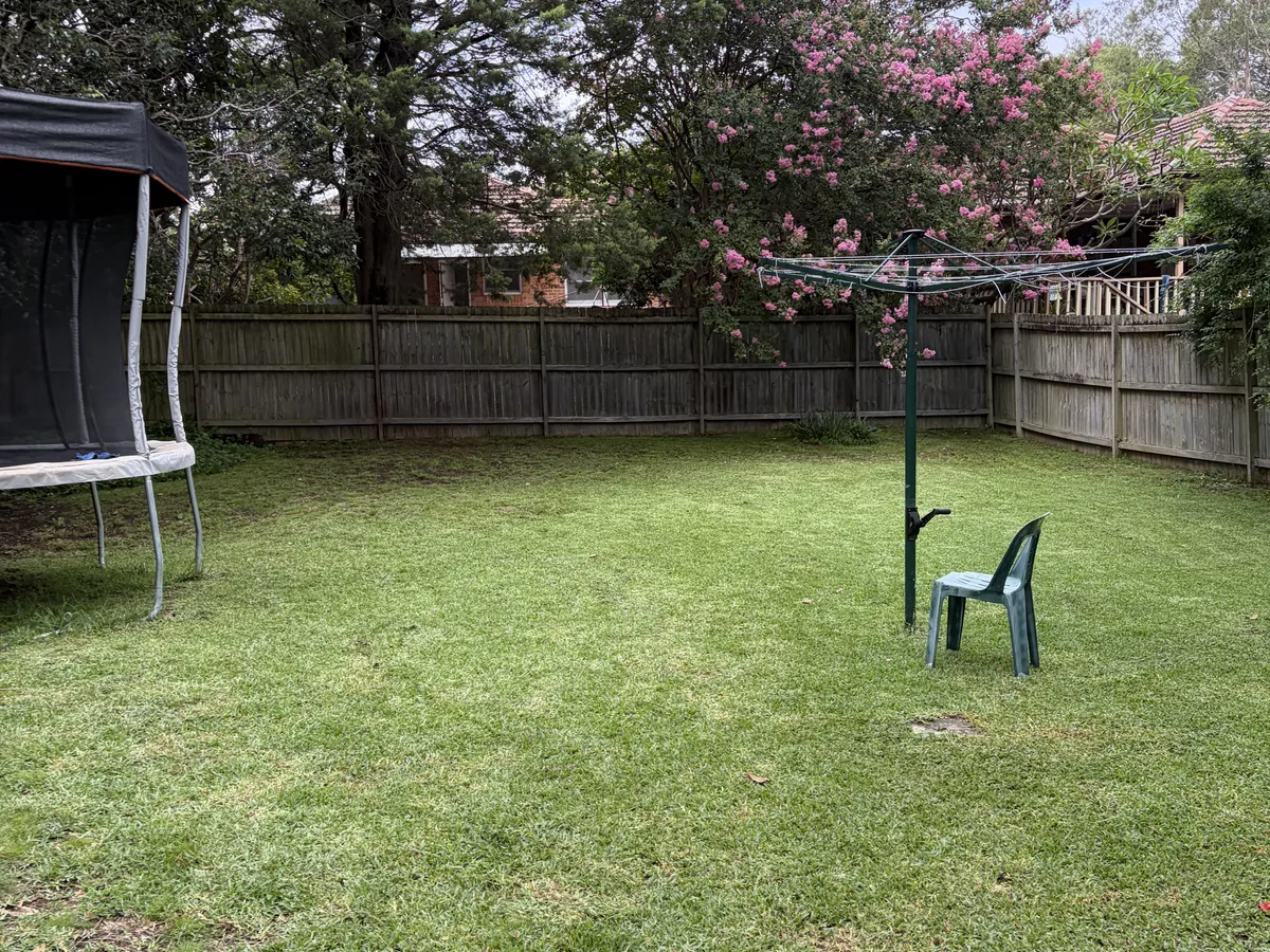 A back lawn mown out around the trampoline and clothesline, by Golden Landscaping